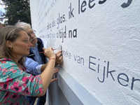 904881 Afbeelding van dichteres Hanneke van Eijken die de letter H schildert van haar voornaam als ondertekening haar ...
